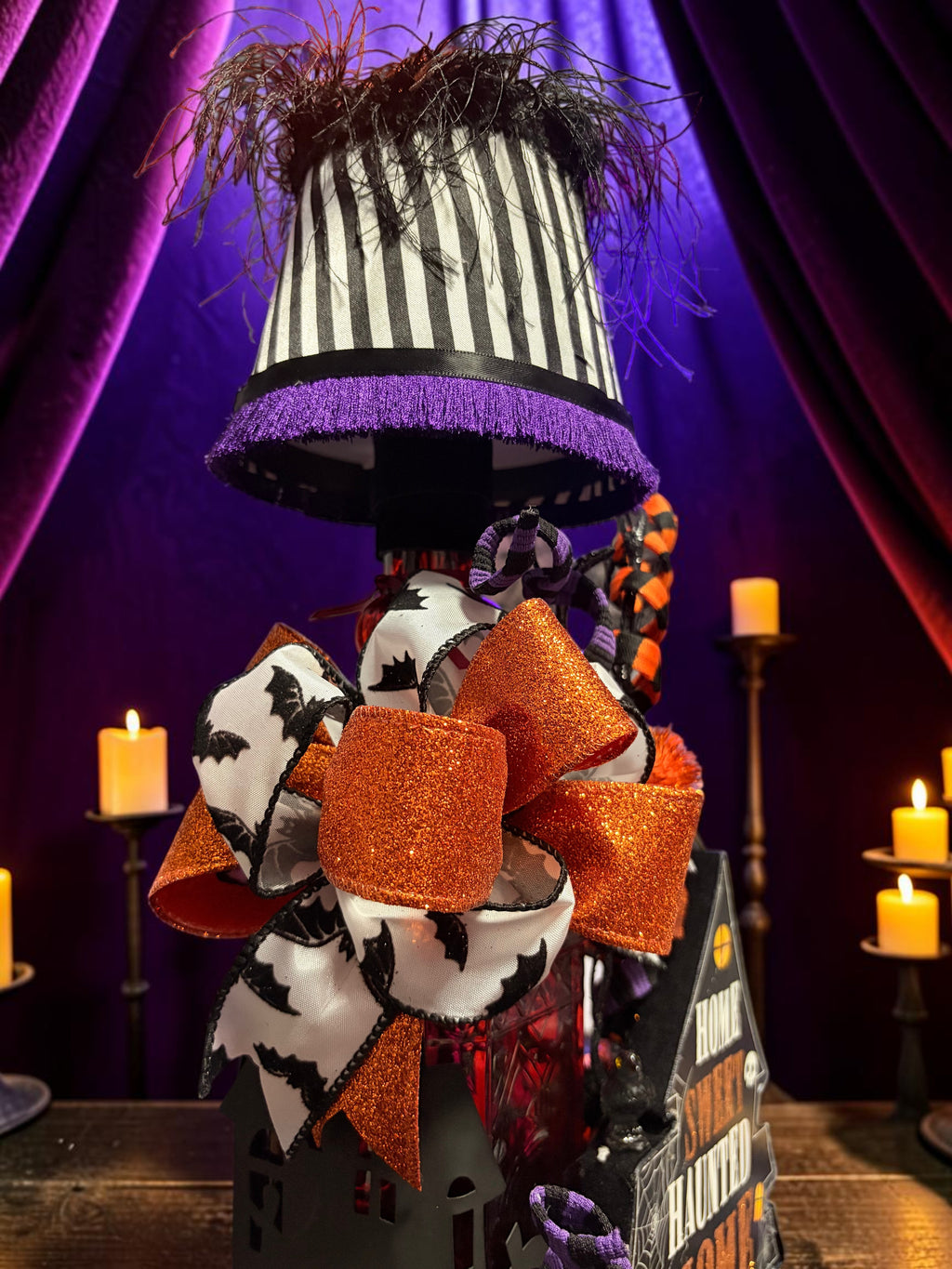 Halloween-Emporium Couture Haunted House Lamp with black and white striped shade, purple fringe, and orange glitter bow