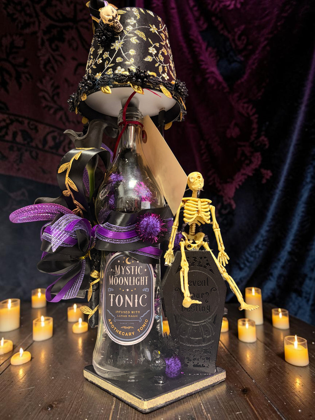 Halloween-Emporium gothic calla lily lamp featuring a Mystic Moonlight Tonic bottle, skeleton, and coffin decor.