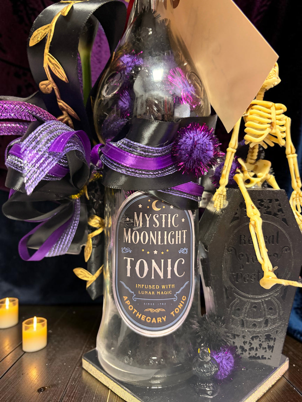 Halloween-Emporium gothic calla lily lamp featuring a Mystic Moonlight Tonic bottle, purple ribbons, and a skeleton.