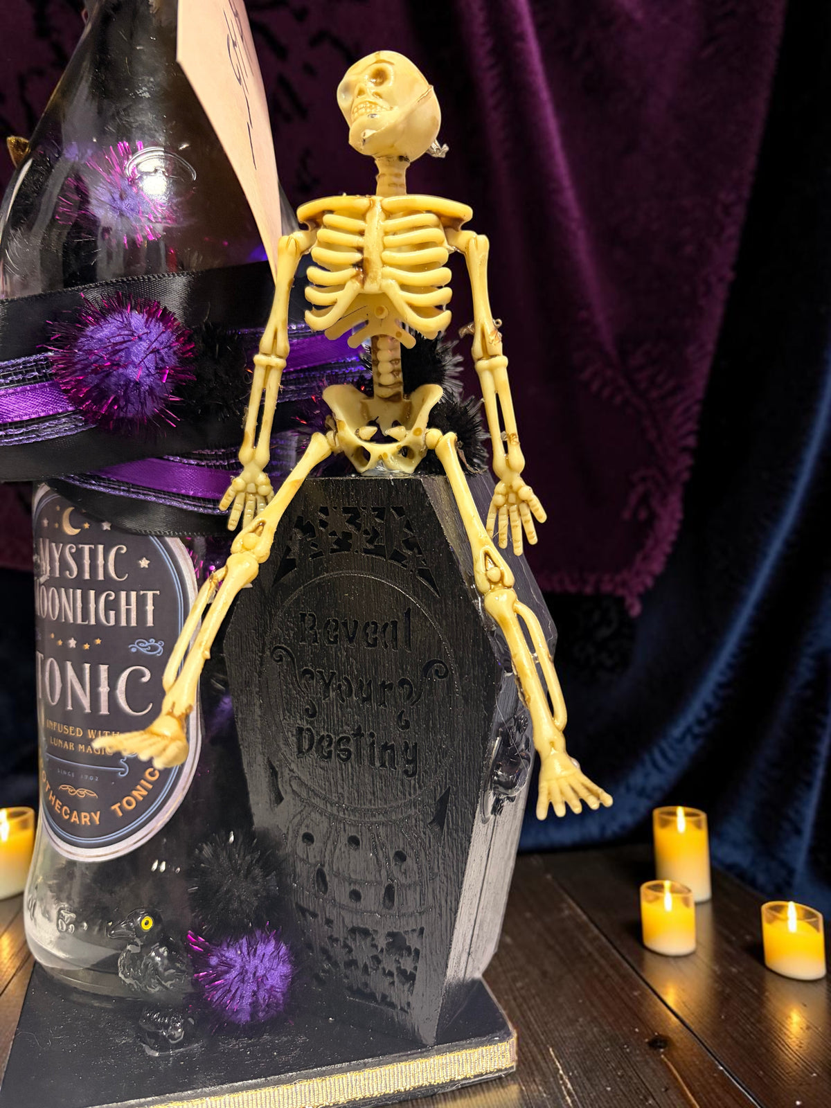 Halloween-Emporium gothic skeleton lamp featuring a black coffin base and Mystic Moonlight Tonic bottle decor