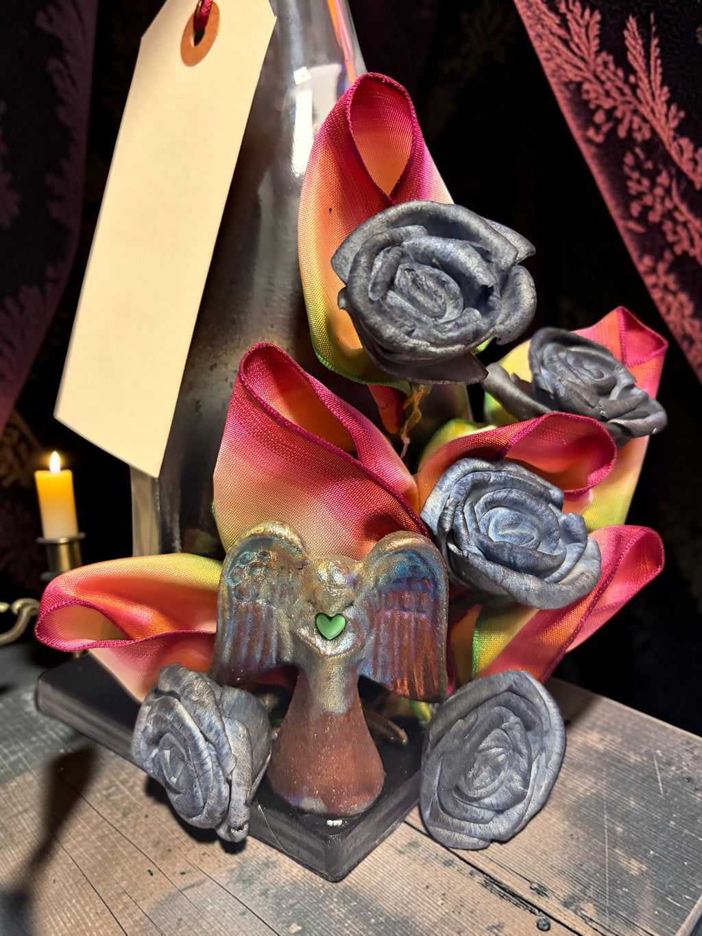 Halloween-Emporium Couture Poison Bottle Lamp featuring dark metallic roses, rainbow ribbon, and a small angel figure.