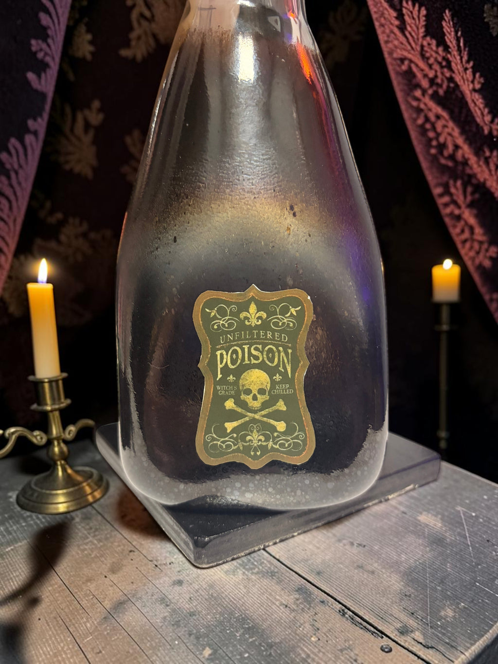 Halloween-Emporium Couture Poison bottle lamp with a dark glass finish and a vintage skull and crossbones label