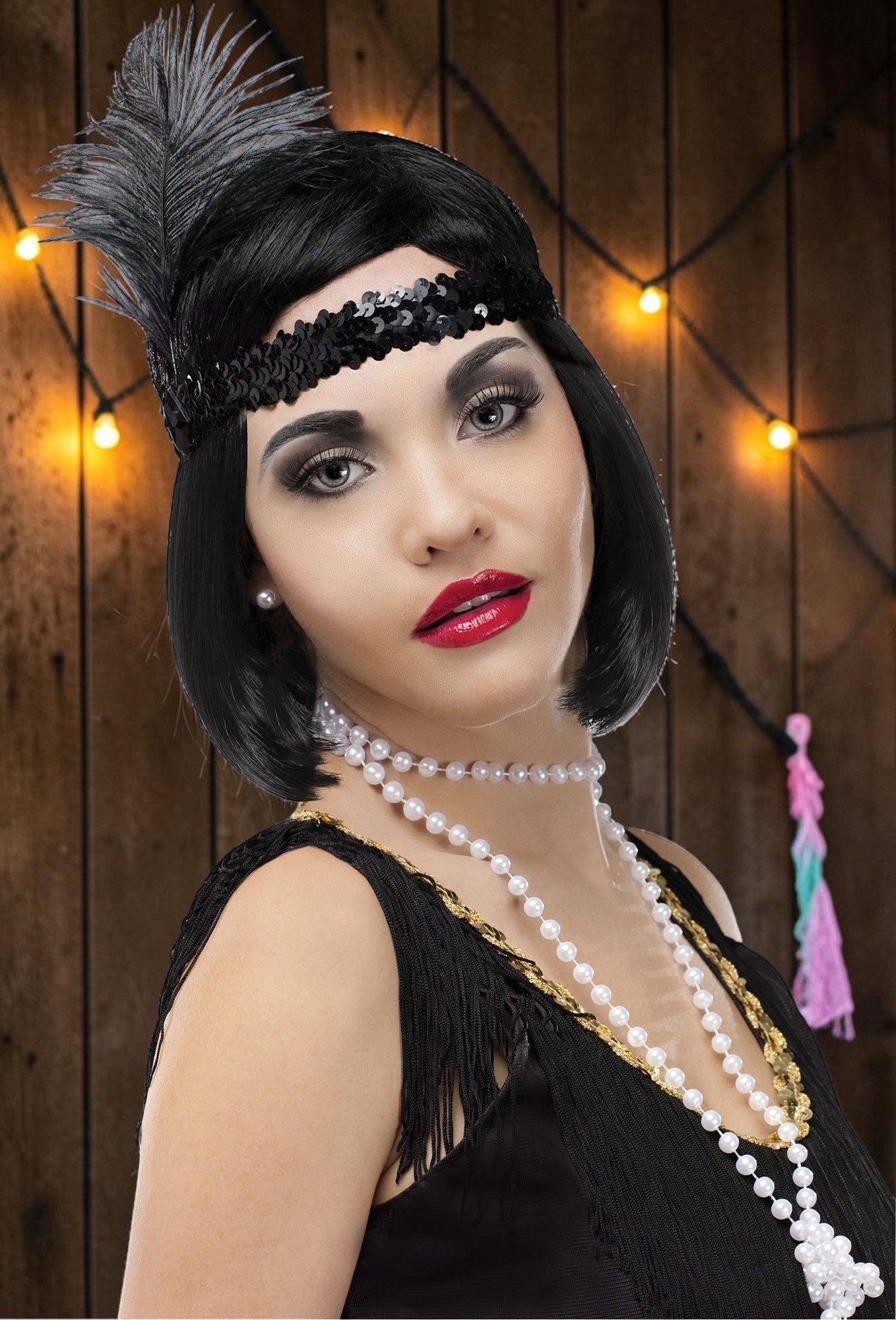 Halloween-Emporium 20s flapper costume kit with black sequin feather headband and pearl necklace on a woman