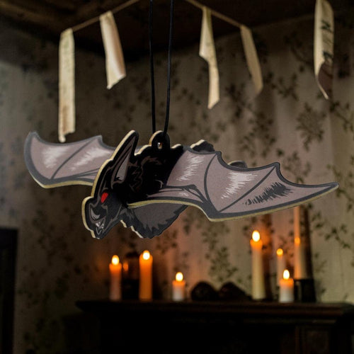 Halloween-Emporium 3D bat air freshener with red eyes and cinnamon scent hanging in a gothic room with candles