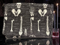 Halloween-Emporium messenger bag with white anatomical skeletal print on black fabric, featuring gothic style design.
