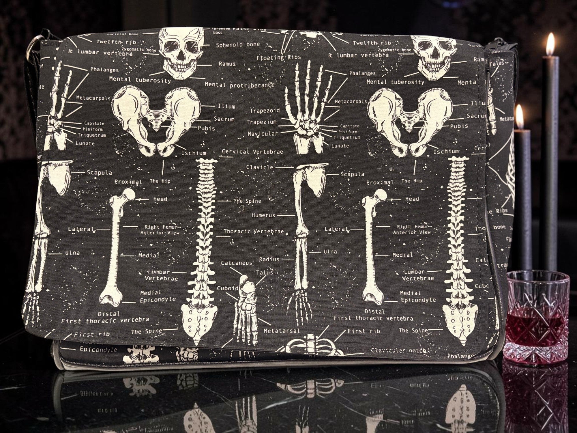 Halloween-Emporium messenger bag with white anatomical skeletal print on black fabric, featuring gothic style design.