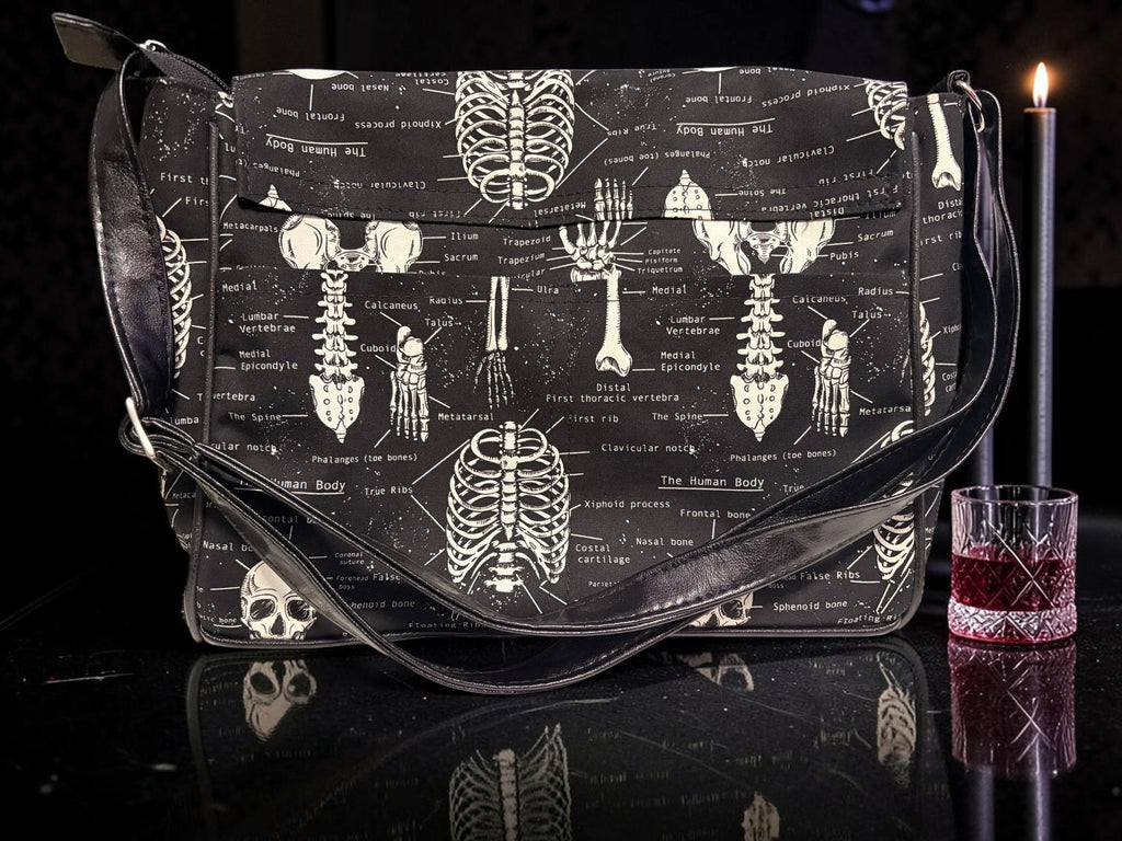 Halloween-Emporium messenger bag featuring a vintage white anatomical skeletal print on a black fabric background