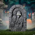 Halloween-Emporium animated tombstone with a skeleton rising from the grave featuring glowing green eyes