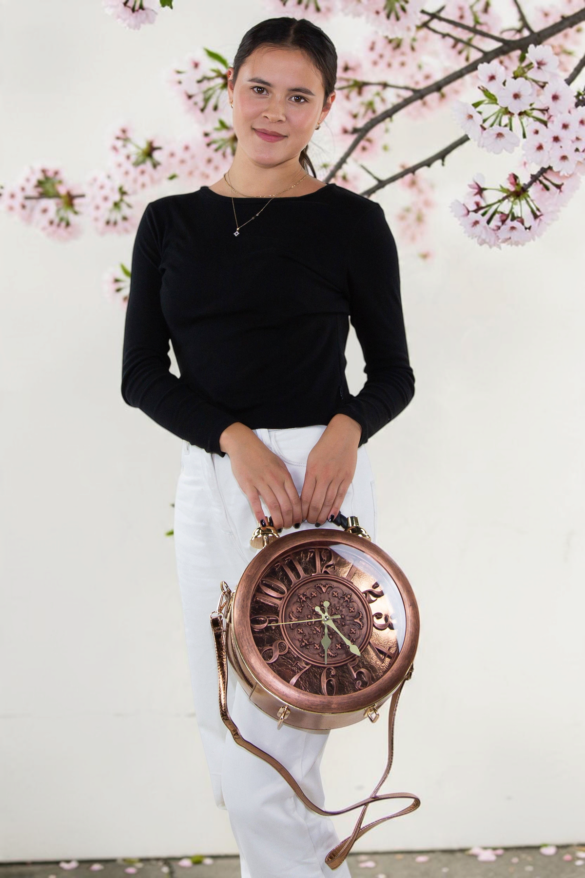 Halloween-Emporium antique clock bag in metallic vinyl with a protective cover, held by a woman in a black top.