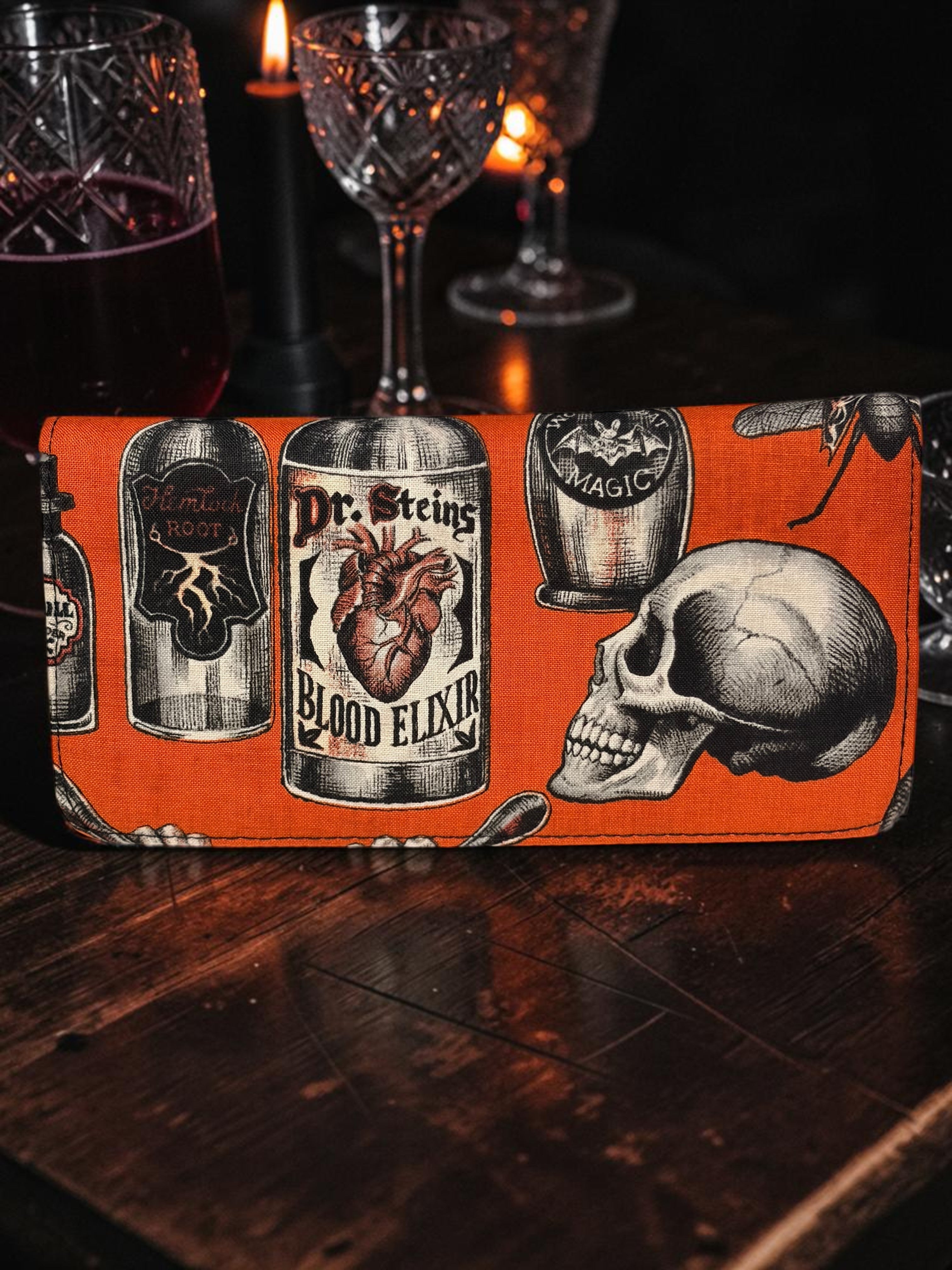 Halloween-Emporium Deadly Apothecary clutch wallet in orange with gothic skull and potion bottle print