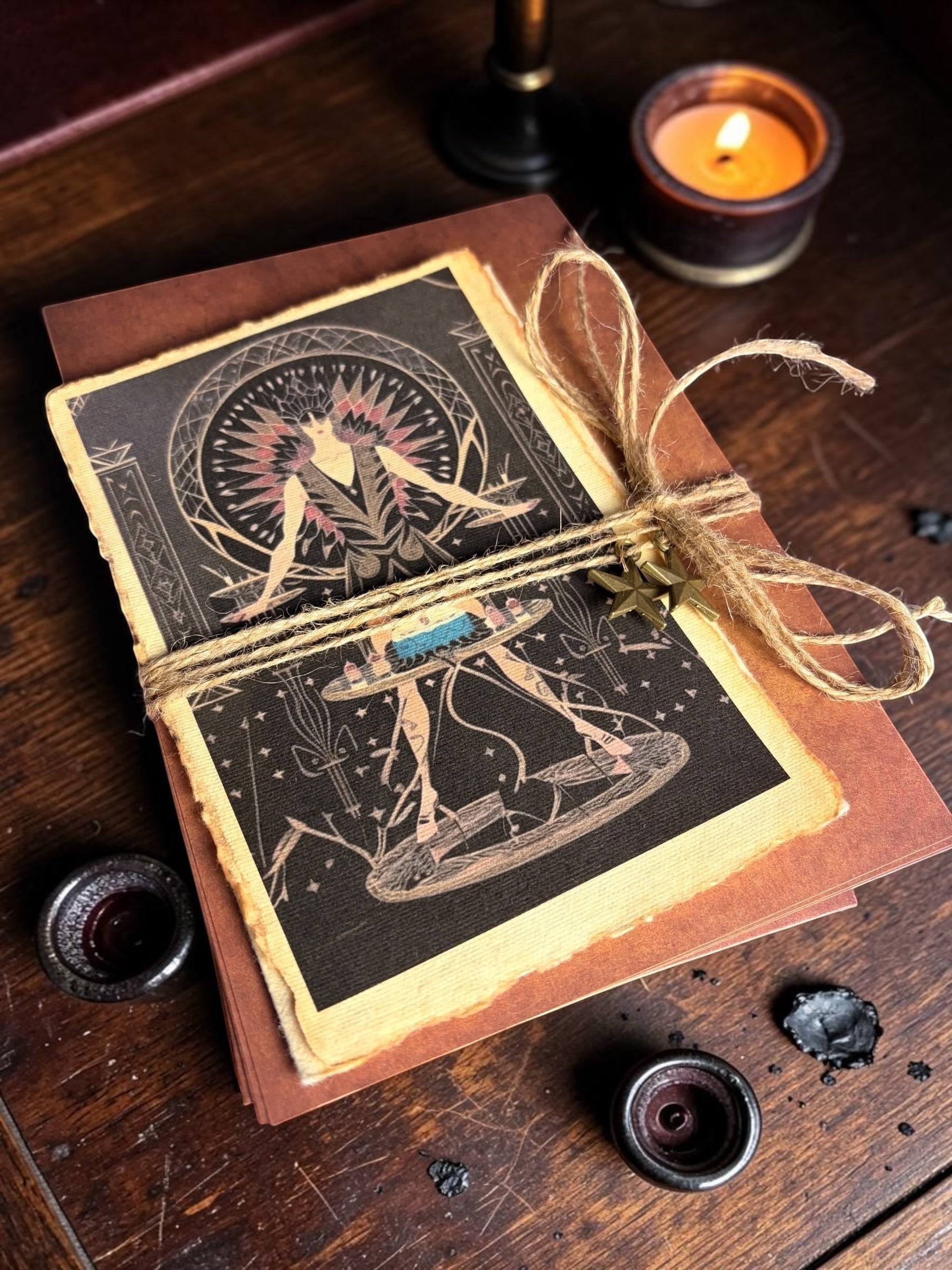 Halloween-Emporium Art Deco greeting card set with deckled-edge paper, twine, and star charms on a dark wood table.