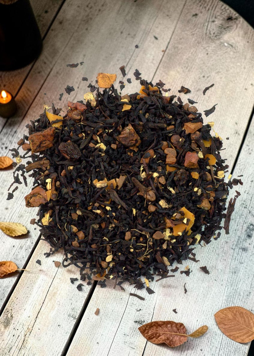 Halloween-Emporium Big Apple Chai loose leaf black tea blend with dried apple pieces, cinnamon, and spices on wood.