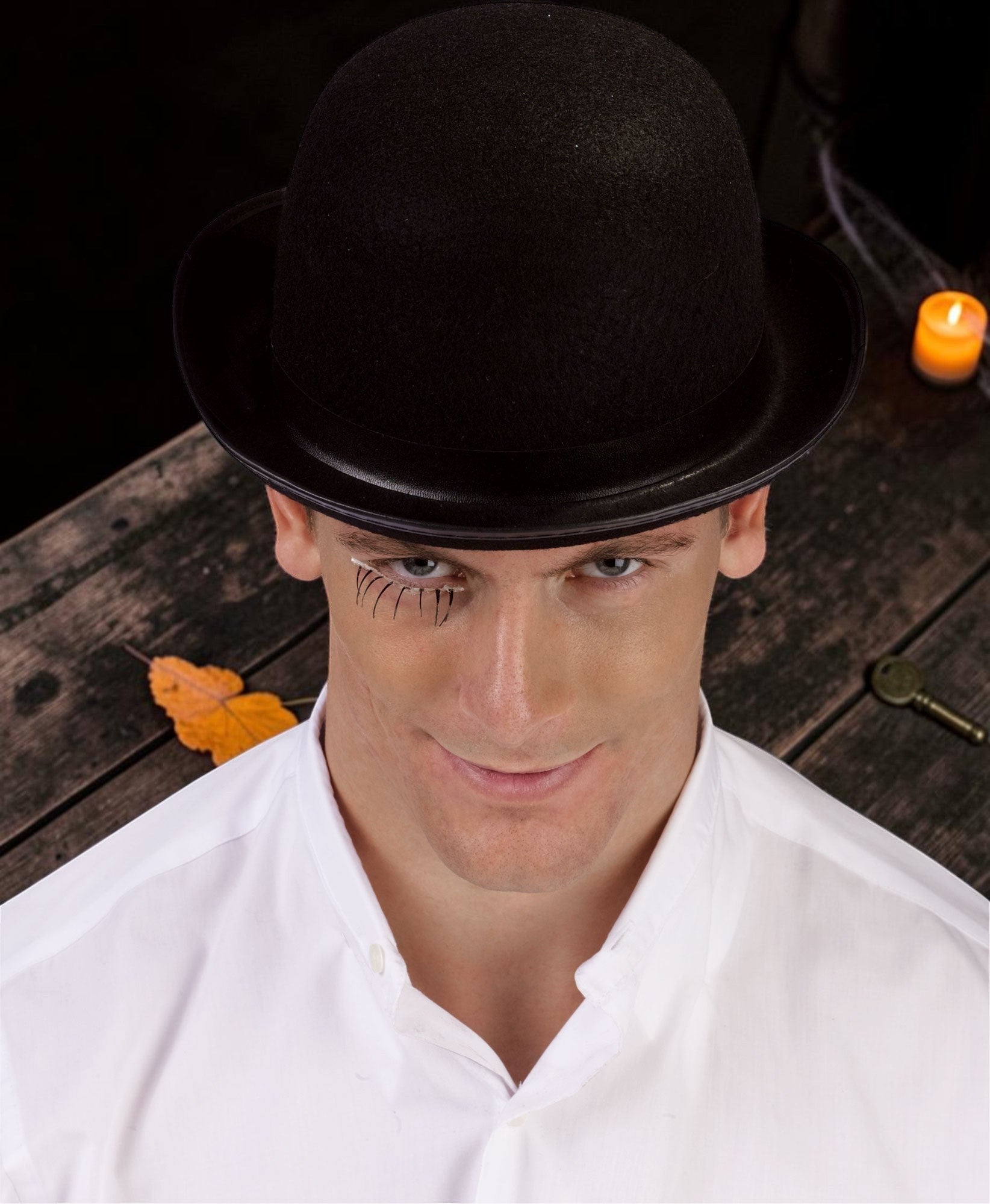 Halloween-Emporium black felt bowler hat worn by a man with stylized eye makeup for a theatrical costume look