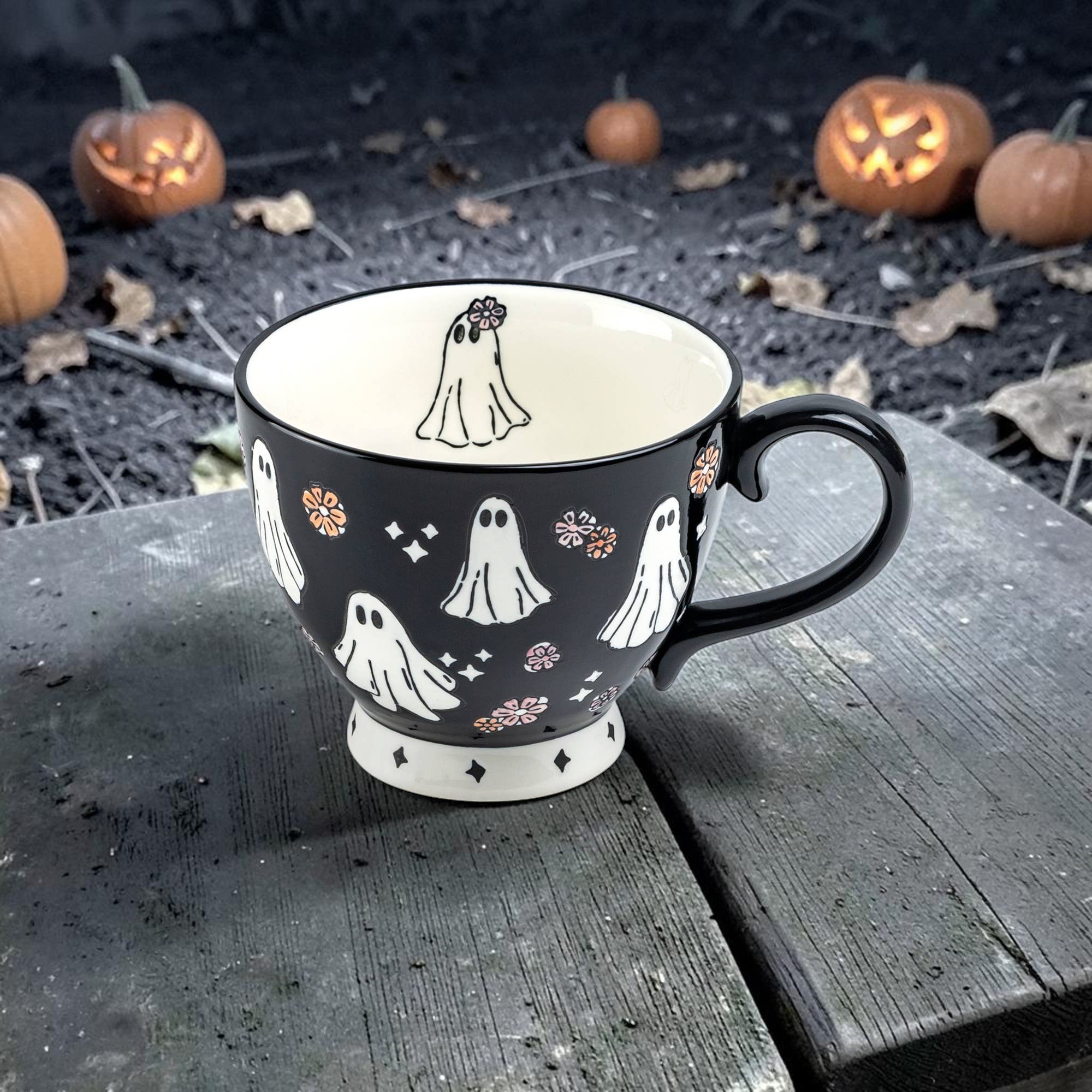 Halloween-Emporium 16oz black ceramic latte mug with white ghost and floral crown pattern and cream interior