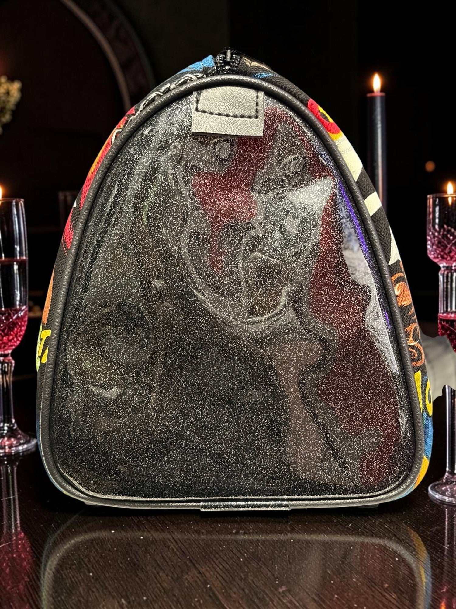 Halloween-Emporium black glittery classic horror handbag with a triangular silhouette on a dark table