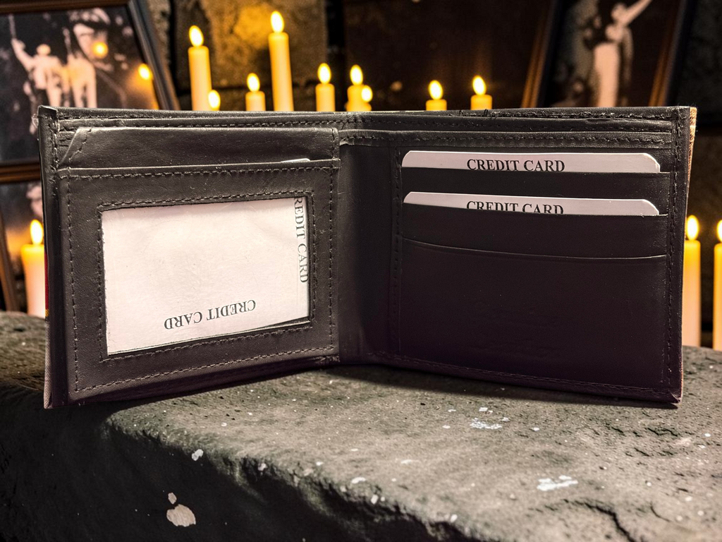Halloween-Emporium hand crafted black leather bifold wallet with credit card slots, displayed on a stone surface.