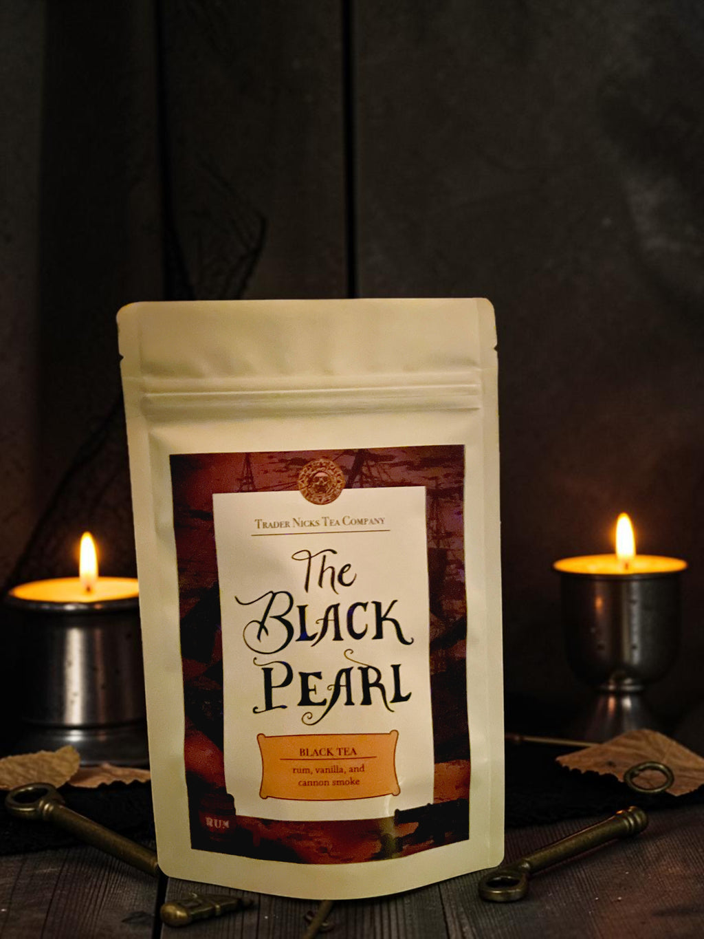 Halloween-Emporium The Black Pearl rum smoke black tea pouch displayed with lit candles and pirate-themed props