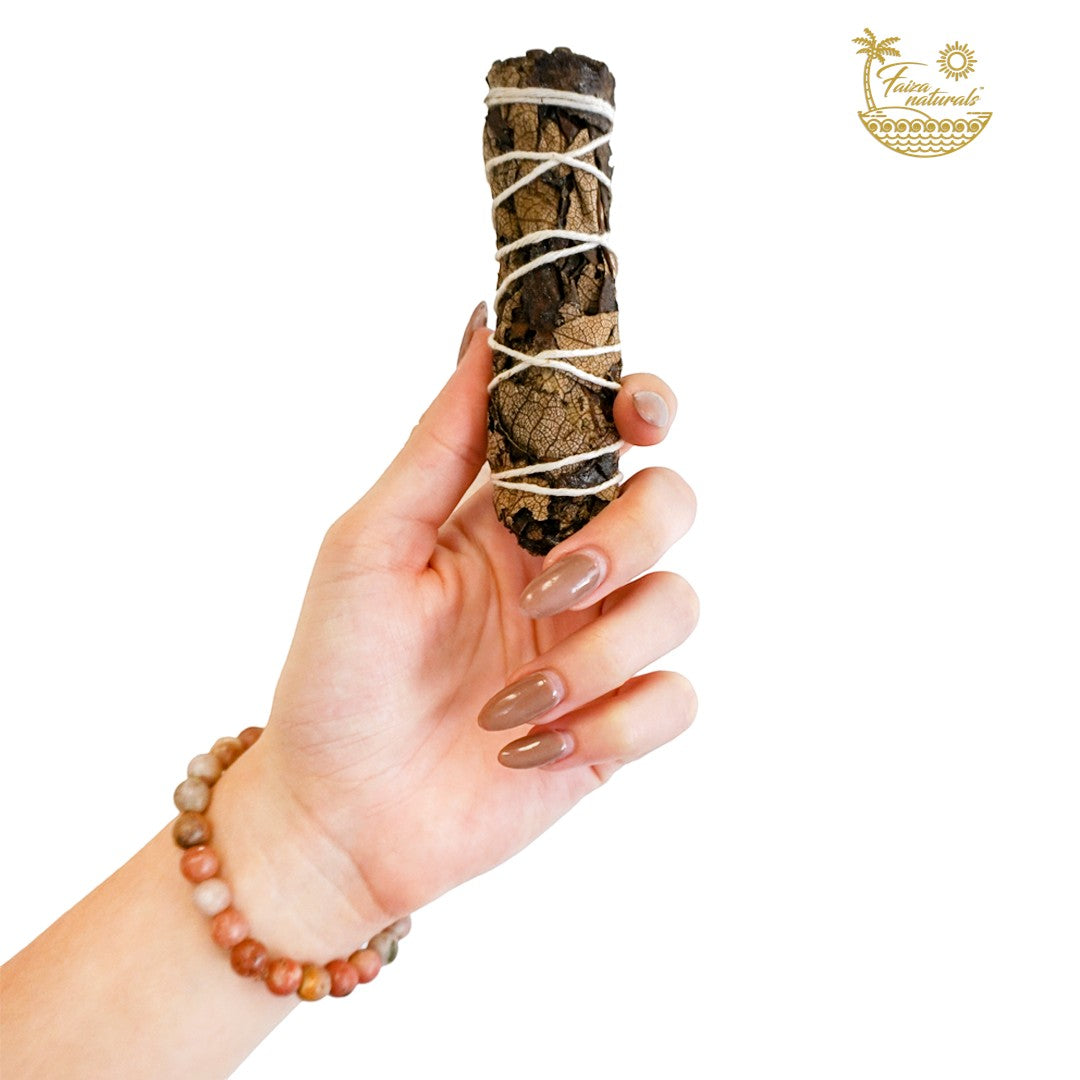 Halloween-Emporium 4-inch hand-tied black sage smudge bundle held in a hand for cleansing and spiritual rituals.