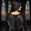 Halloween-Emporium black sequin angel wings worn by a woman in a gothic setting for a dark fairy or fallen angel costume.