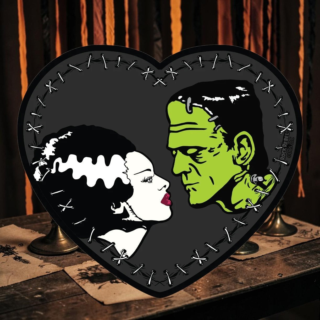 Halloween-Emporium Bride of Frankenstein heart sticker featuring a green monster and his bride in a stitched frame.