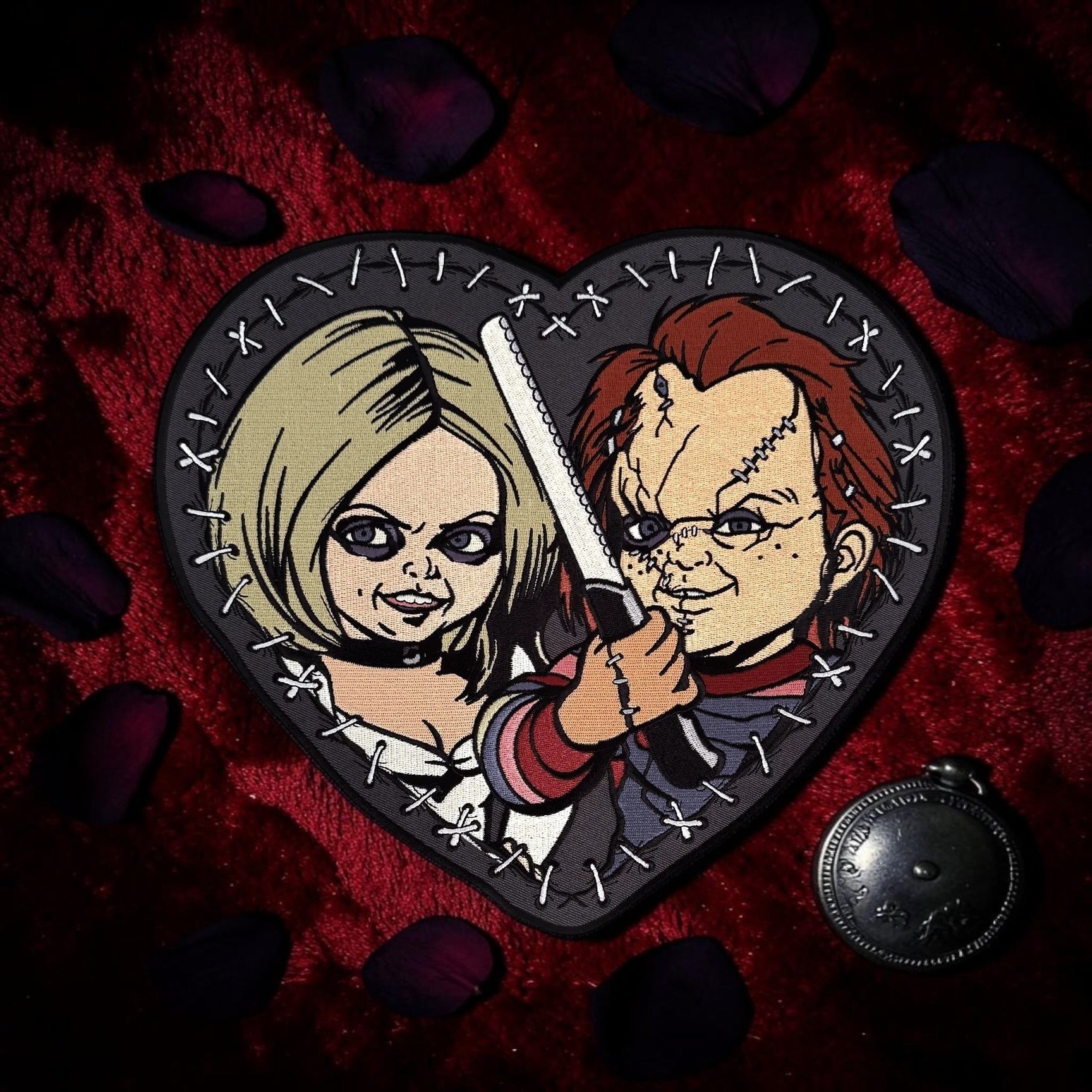 Halloween-Emporium Bride of Chucky heart-shaped embroidered back patch featuring Chucky and Tiffany on red velvet.