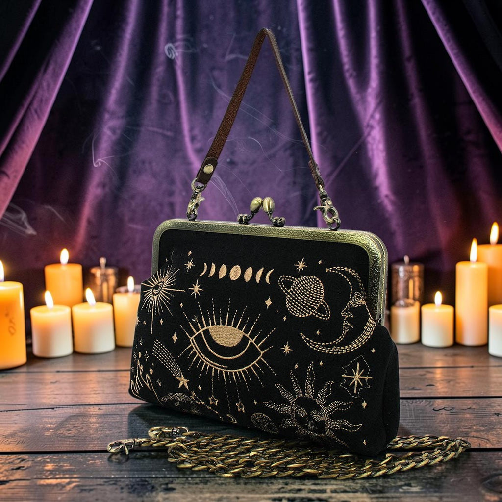 Halloween-Emporium black kisslock handbag with gold celestial embroidery, featuring a wrist strap and chain shoulder strap