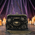 Halloween-Emporium black kisslock handbag with gold celestial embroidery, featuring moon and eye motifs on a table.
