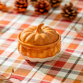 Halloween-Emporium orange and white ceramic pumpkin serving dish with lid on a plaid autumn tablecloth