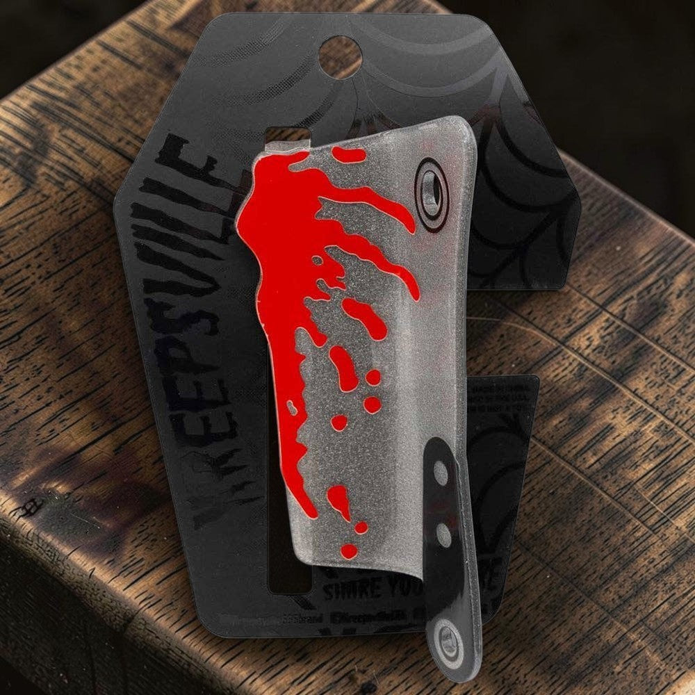 Halloween-Emporium silver glitter cleaver claw clip with red blood splatter on a coffin-shaped display card.
