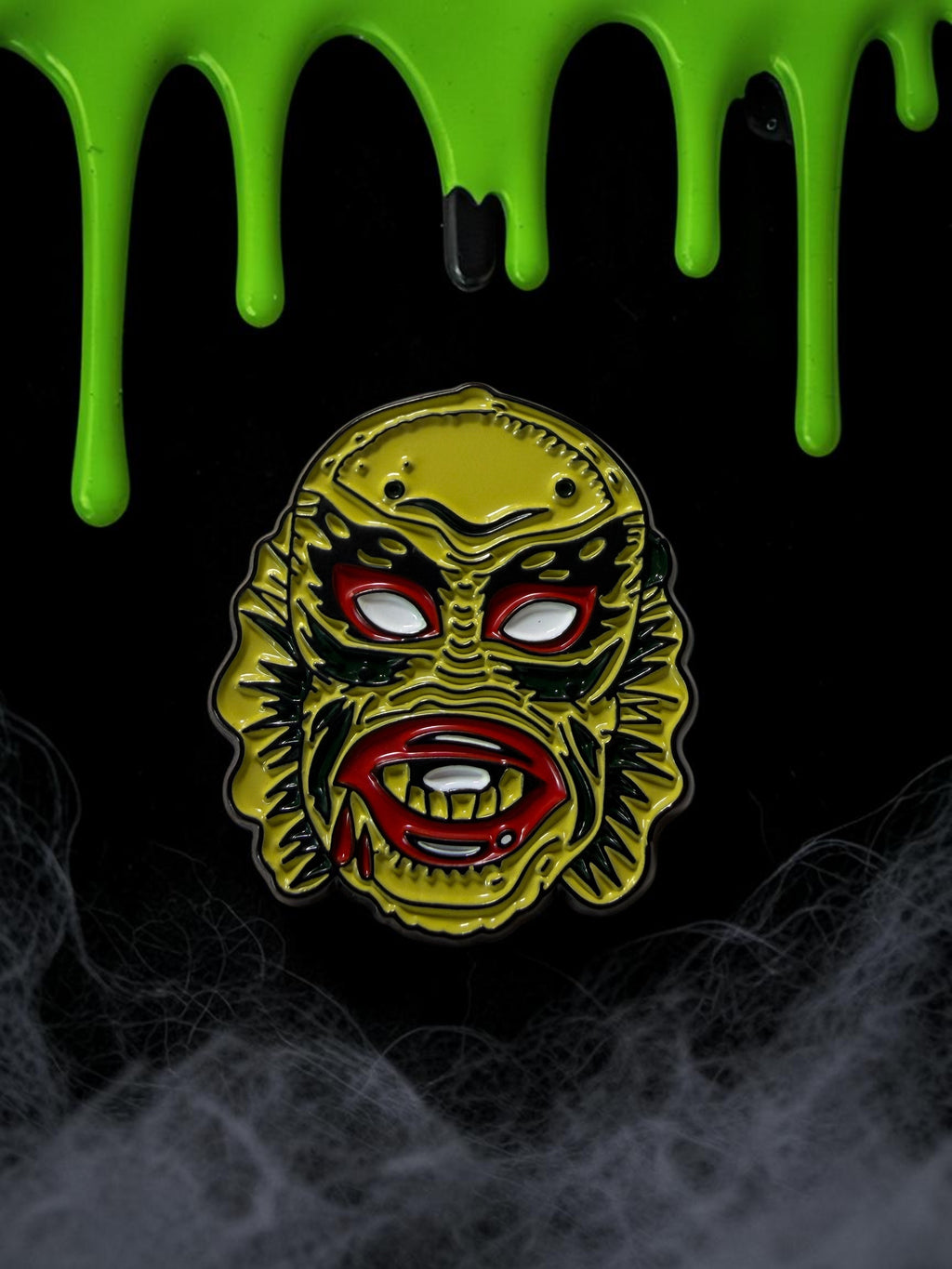 Halloween-Emporium 1.25 inch enamel pin featuring the Creature from the Black Lagoon with yellow, red, and black detail