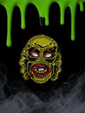 Halloween-Emporium 1.25 inch enamel pin featuring the Creature from the Black Lagoon with yellow, red, and black detail