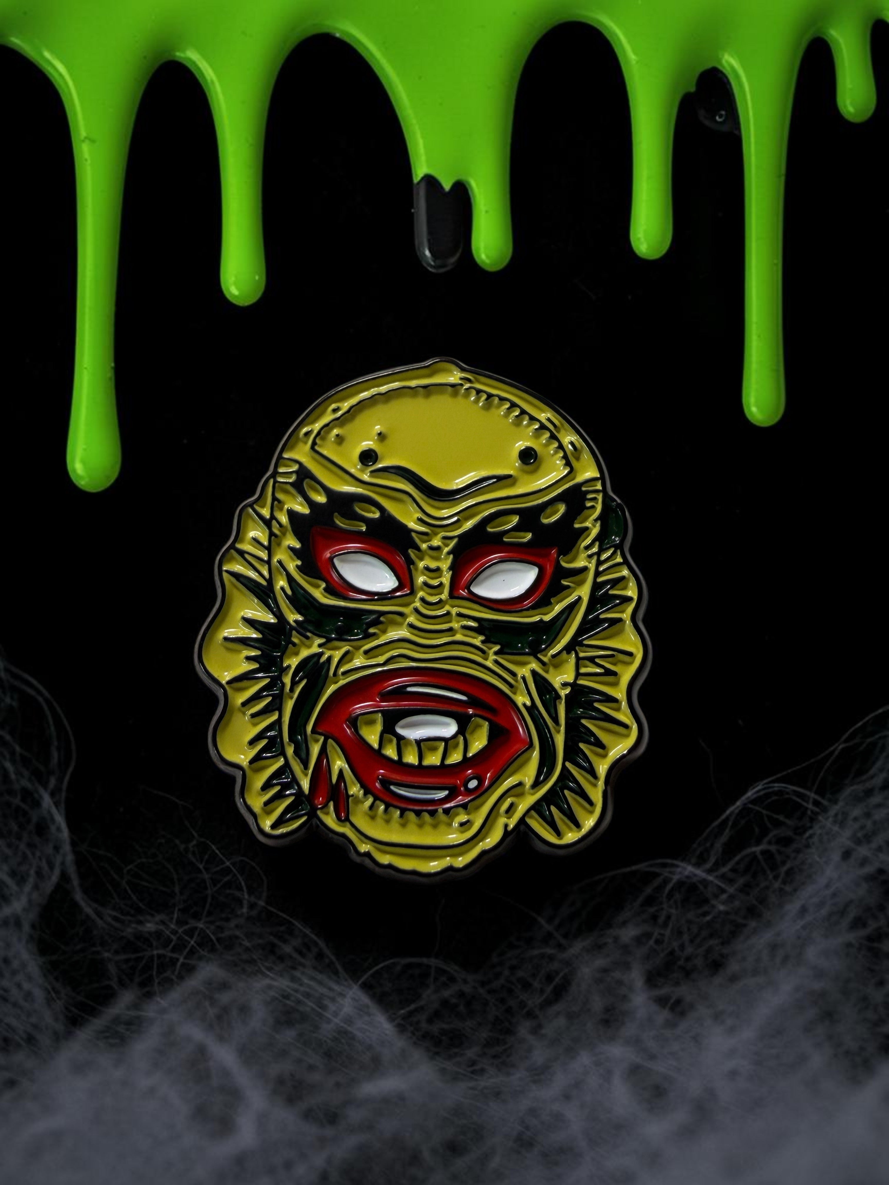 Halloween-Emporium 1.25 inch enamel pin featuring the Creature from the Black Lagoon with yellow, red, and black detail