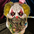 Halloween-Emporium Charles Demon of Gluttony latex clown mask with yellow hair, sharp teeth, and grotesque details.