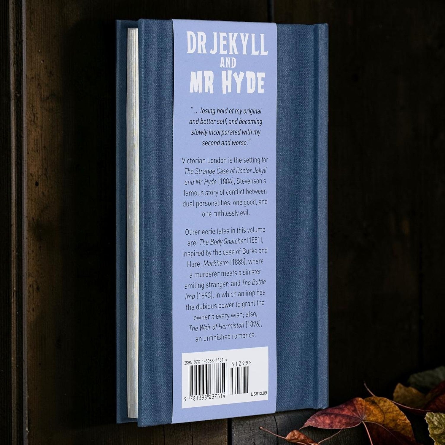 Halloween-Emporium Dr Jekyll and Mr Hyde hardcover book with blue embossed cover and back blurb on wooden surface