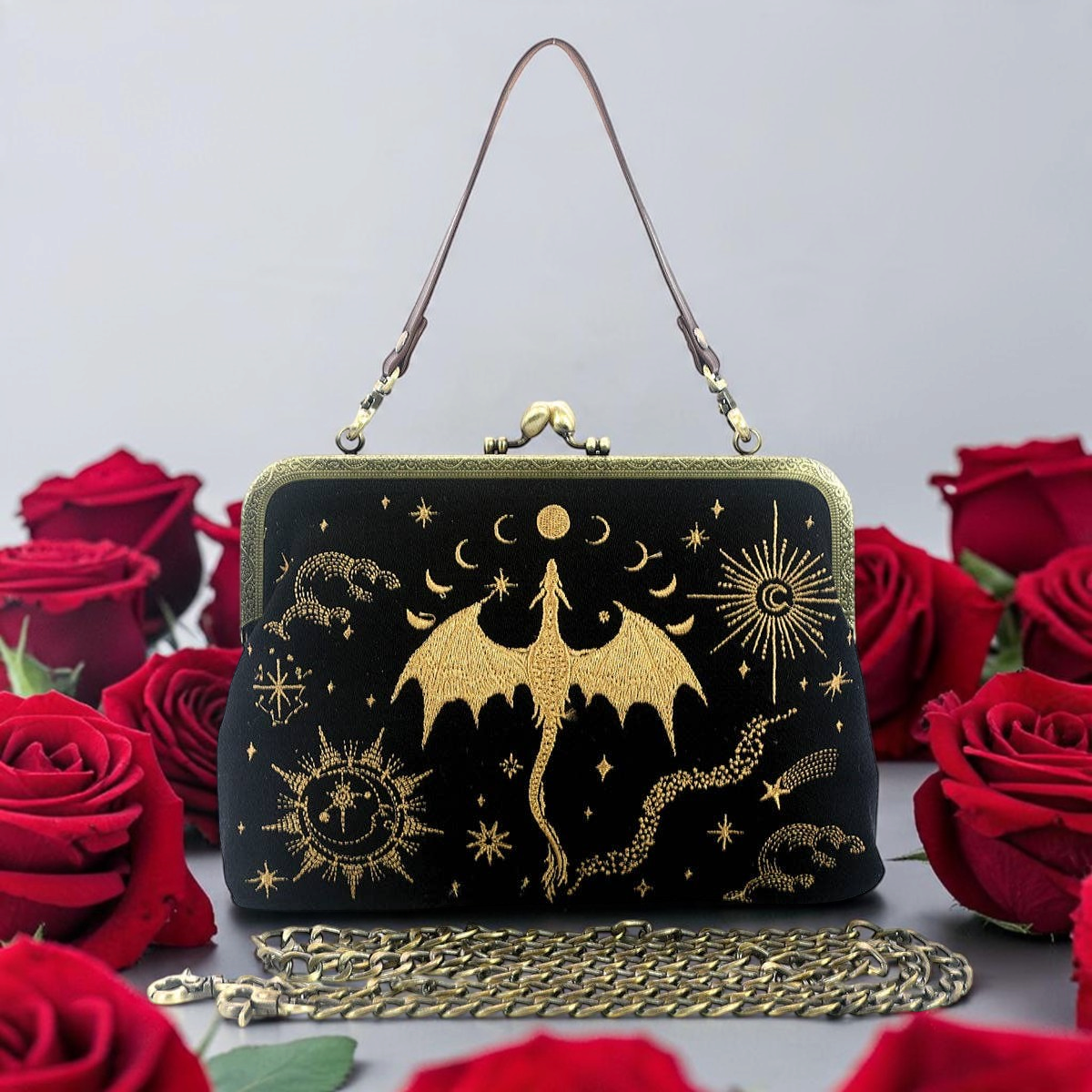 Halloween-Emporium black linen cotton kiss lock bag with gold embroidered dragon and celestial motifs among red roses.