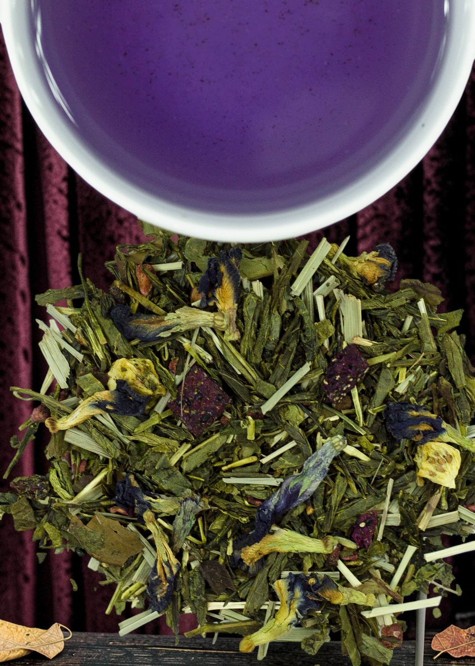 Halloween-Emporium Dragon Queen green tea blend with butterfly pea blossoms, dried fruit, and a cup of purple tea.