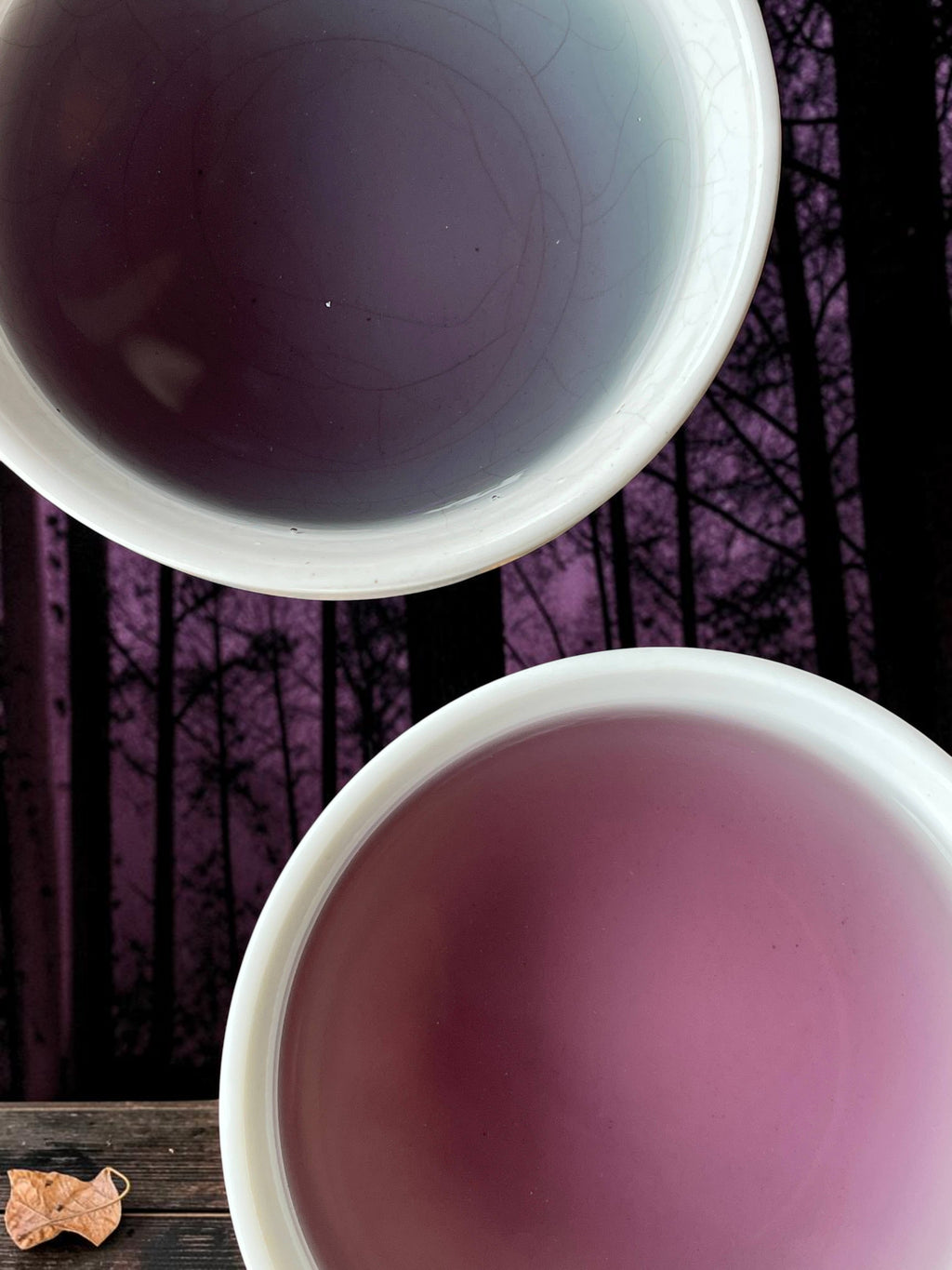 Halloween-Emporium Dragon Queen green tea brewed in two white cups showing deep purple and magenta hues.