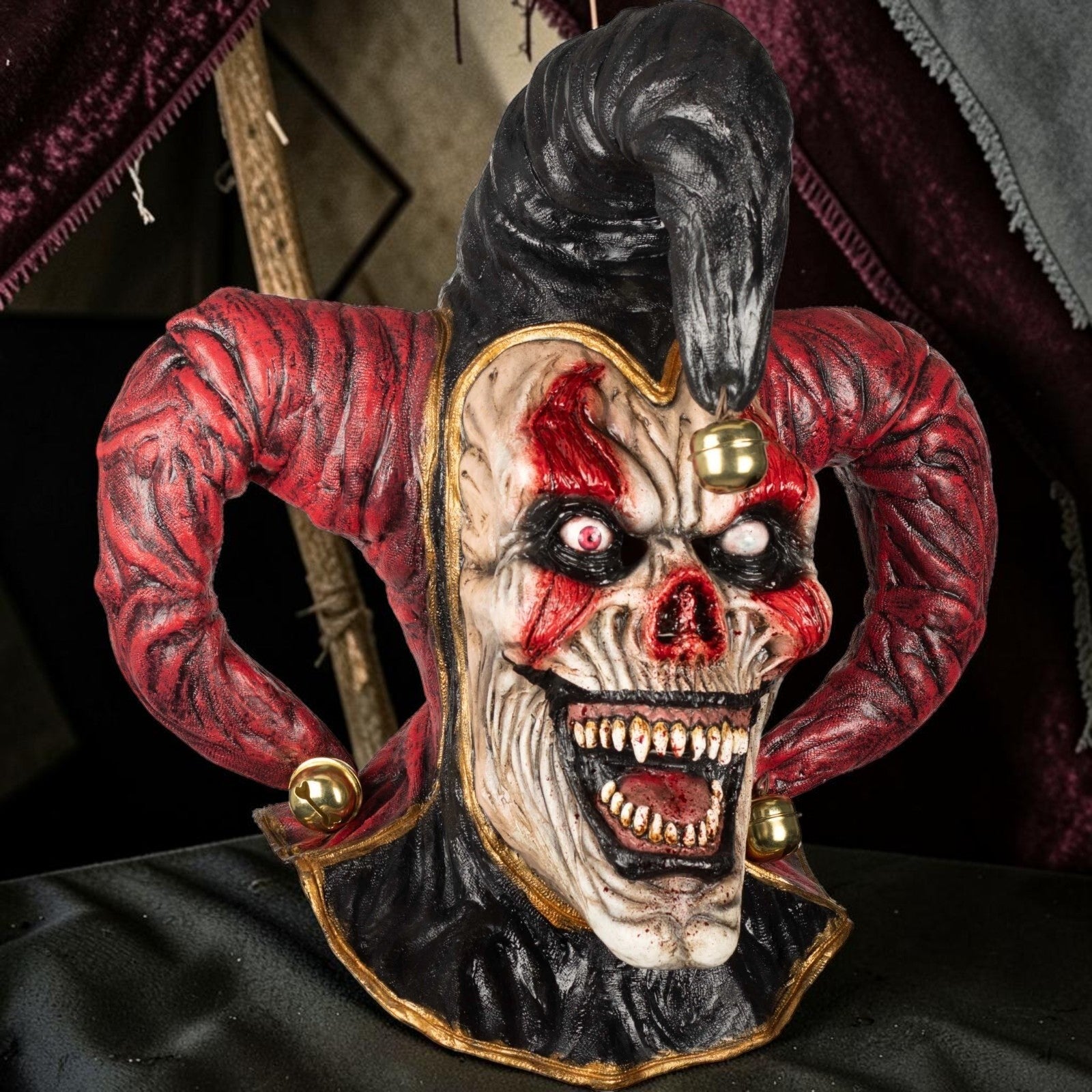 Halloween-Emporium hand-sculpted latex evil jester mask with extended neck, red and black details, and sinister grin.