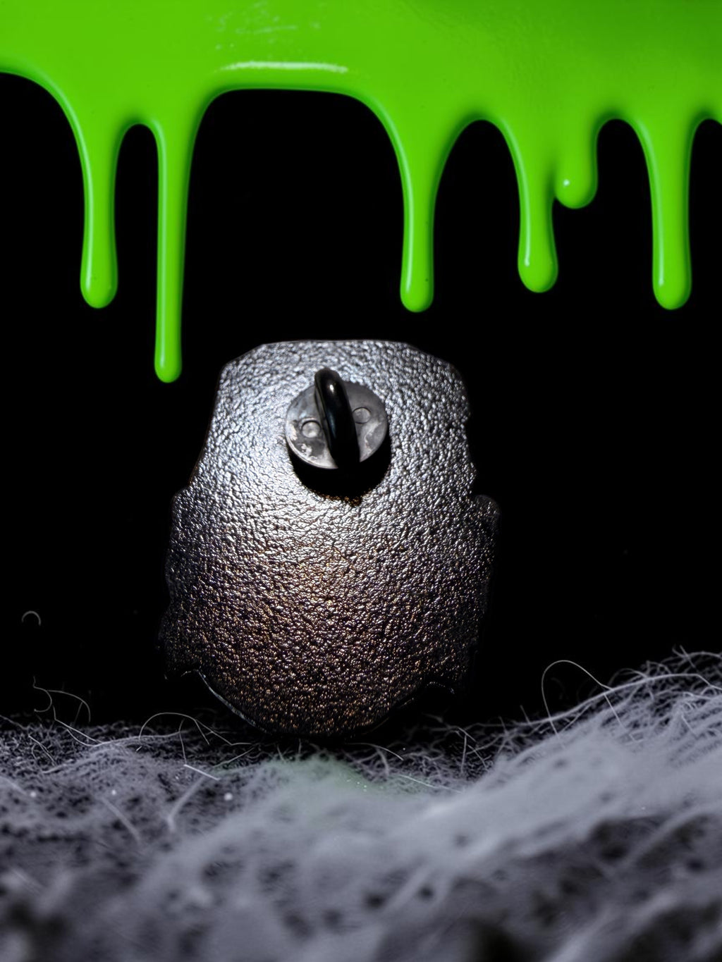 Back view of a Halloween-Emporium Frankenstein enamel pin featuring a textured black metal finish and secure backing.