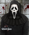Halloween-Emporium Ghost Face 25th Anniversary movie mask with black fabric hood against a blood-splattered wall