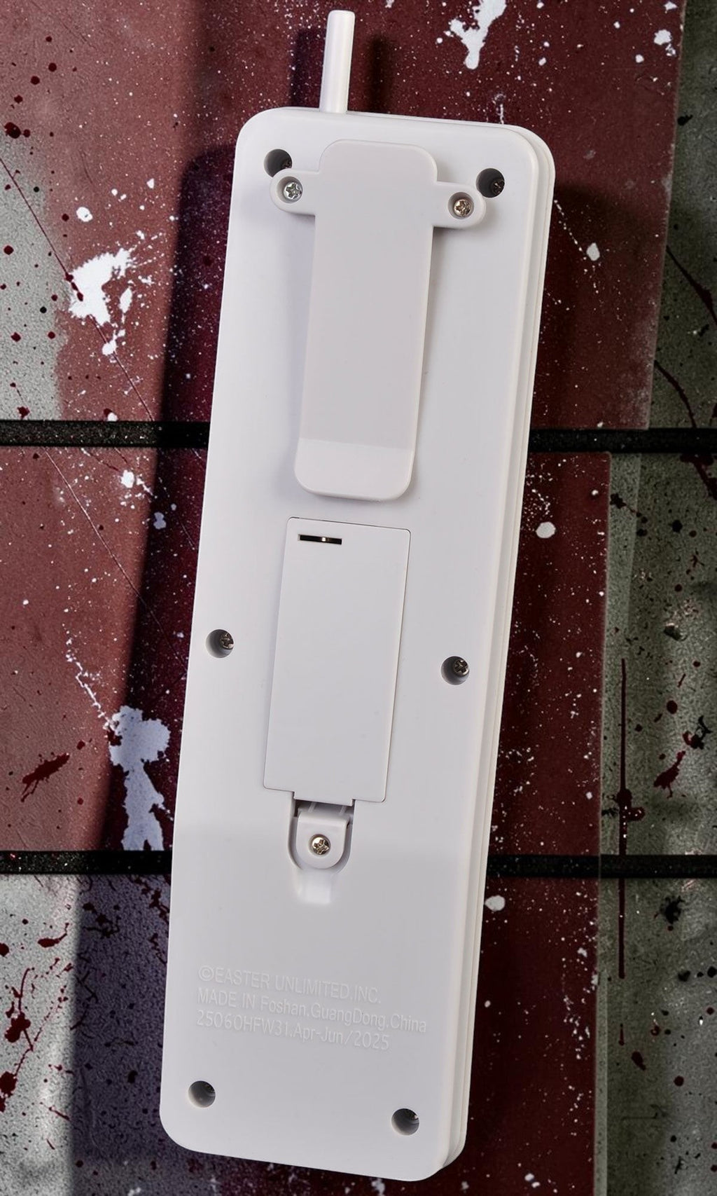 Halloween-Emporium Ghost Face phone prop back view showing the white plastic casing, belt clip, and battery compartment.