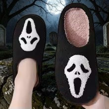 Halloween-Emporium plush black house slippers featuring a white Ghost Face mask design for horror movie fans
