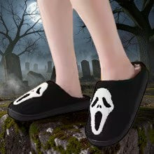 Halloween-Emporium black plush house slippers featuring a white Ghost Face mask design for horror fans.