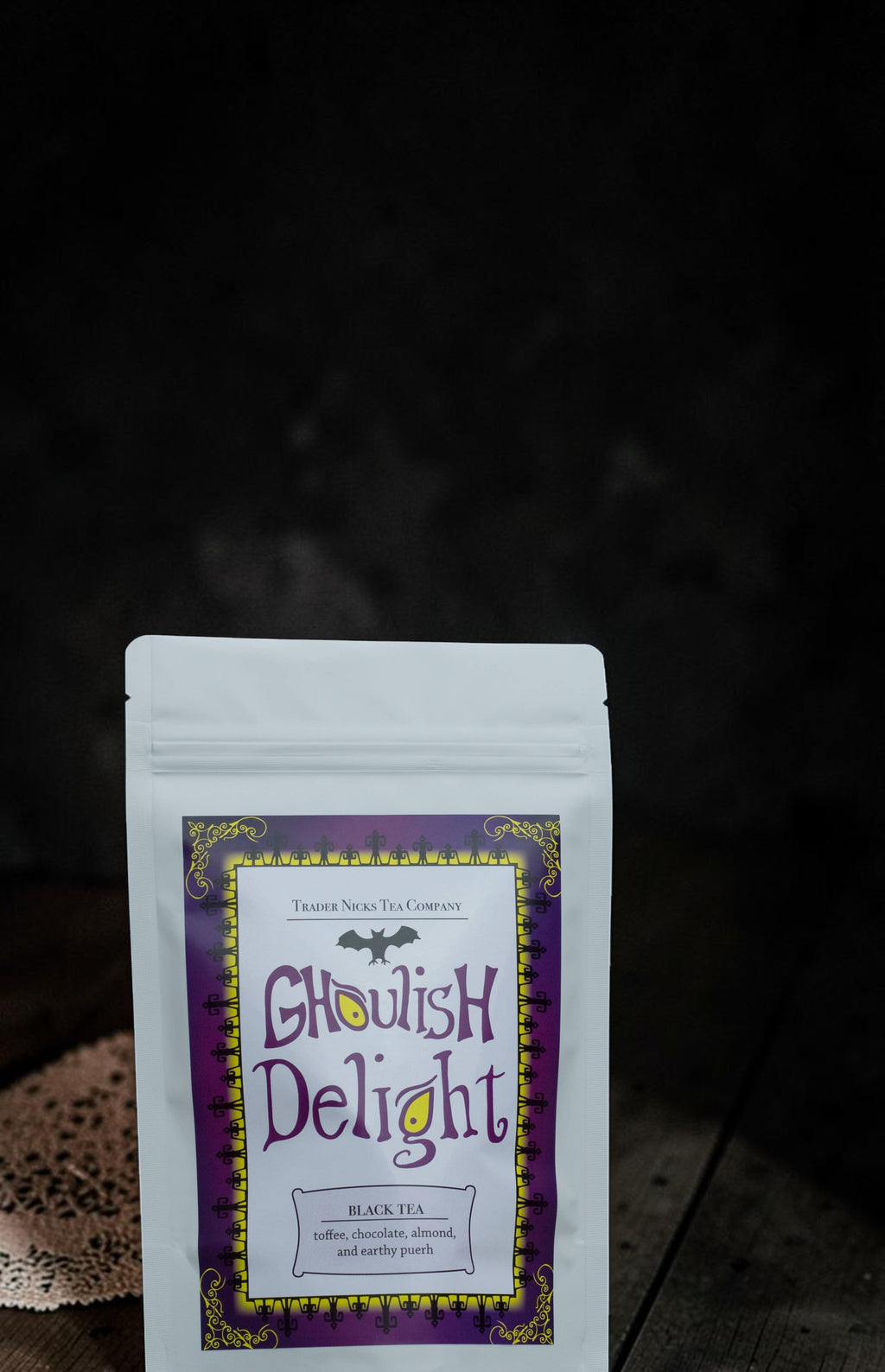 Halloween-Emporium Ghoulish Delight black tea pouch with purple and yellow label featuring a bat and spooky design