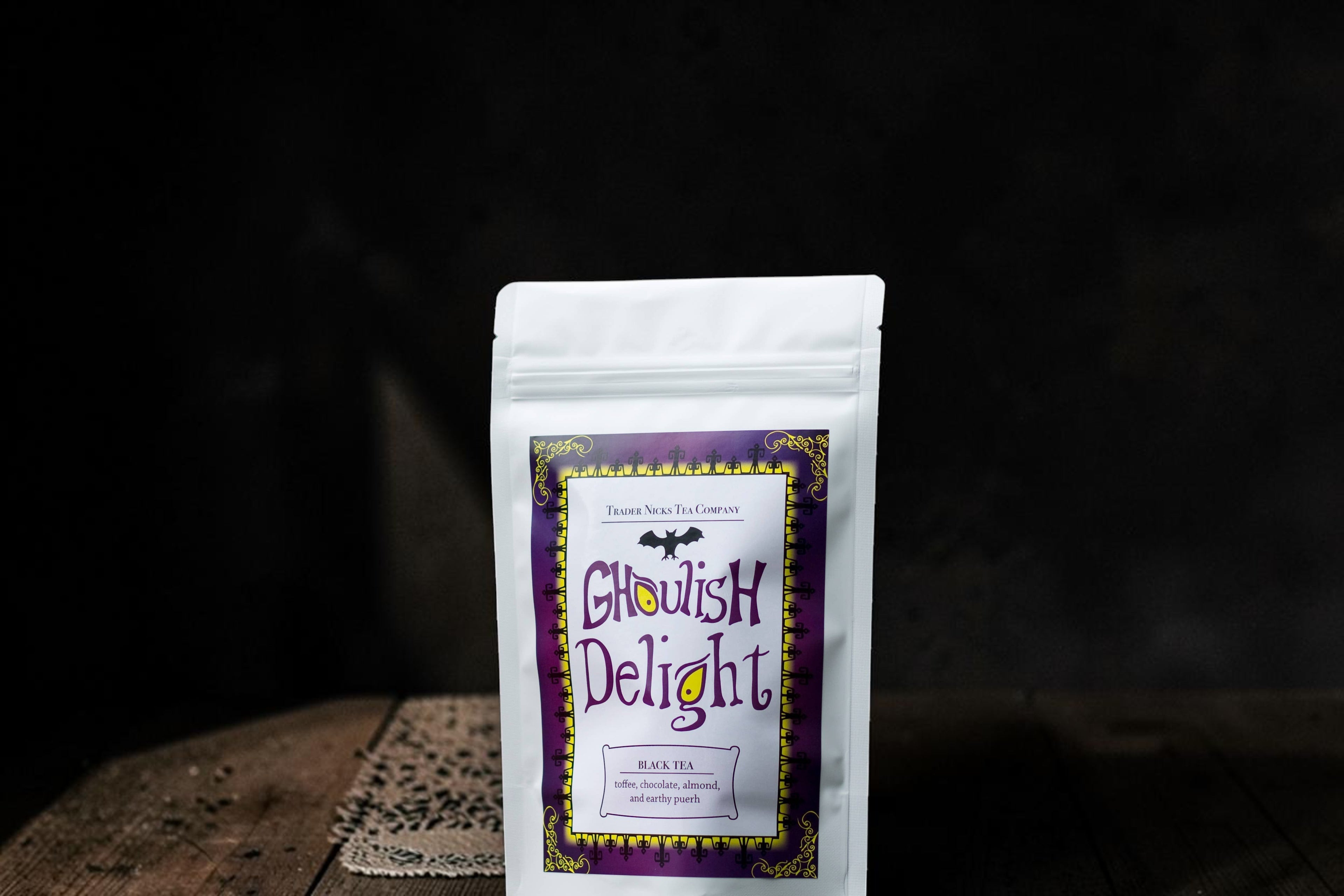 Halloween-Emporium Ghoulish Delight chocolate black tea in a white stand-up pouch with a purple gothic label.