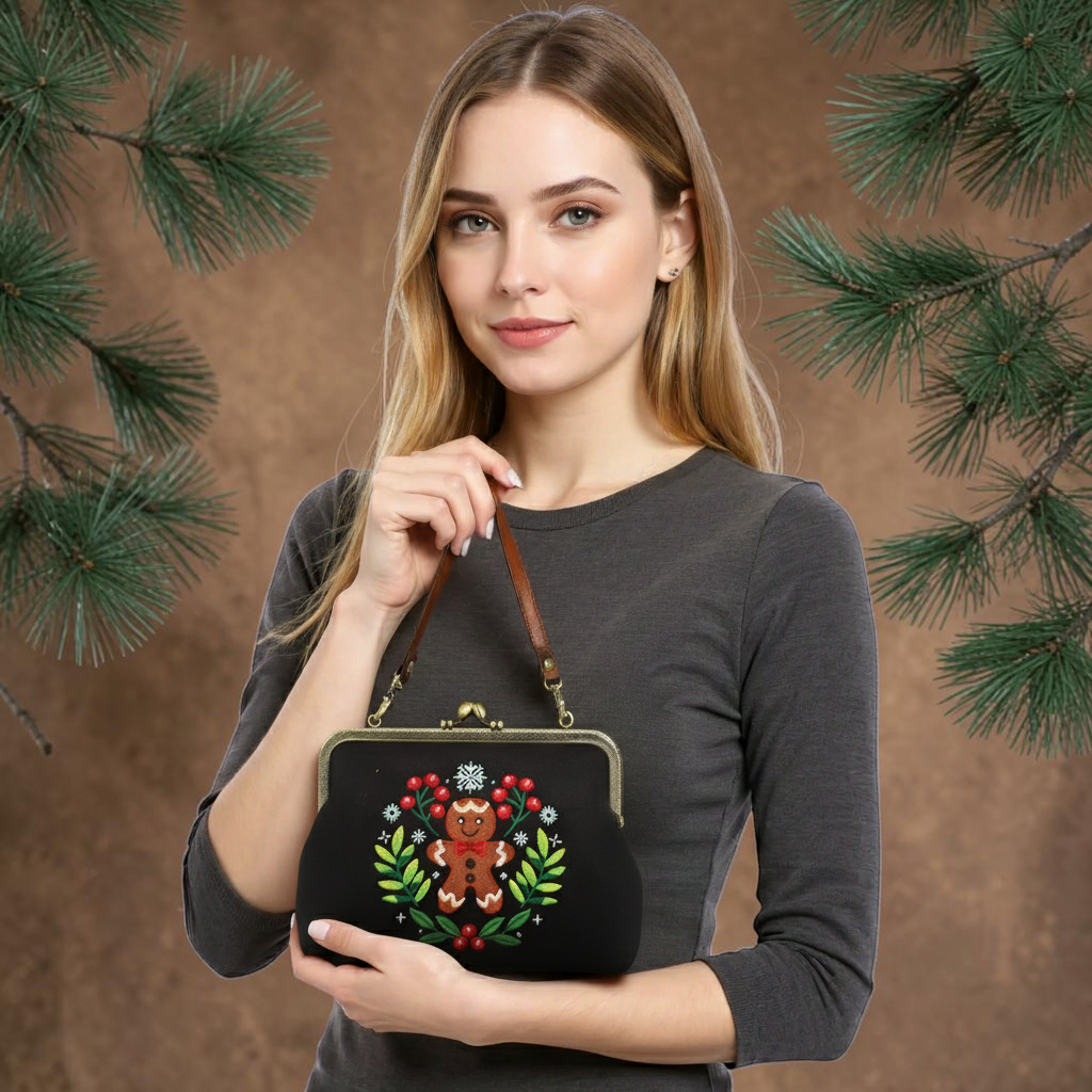 Halloween-Emporium gingerbread man kisslock bag held by a woman, featuring embroidered cookie design on black fabric.