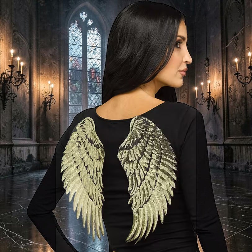 Halloween-Emporium decorative gold sequin angel wings worn by a woman against a gothic castle backdrop.