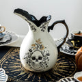 Halloween-Emporium gothic skull ceramic pitcher in white stoneware with black and gold floral detailing.