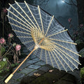Halloween-Emporium gothic parasol with white spider web pattern on a bamboo frame in a dark garden setting.