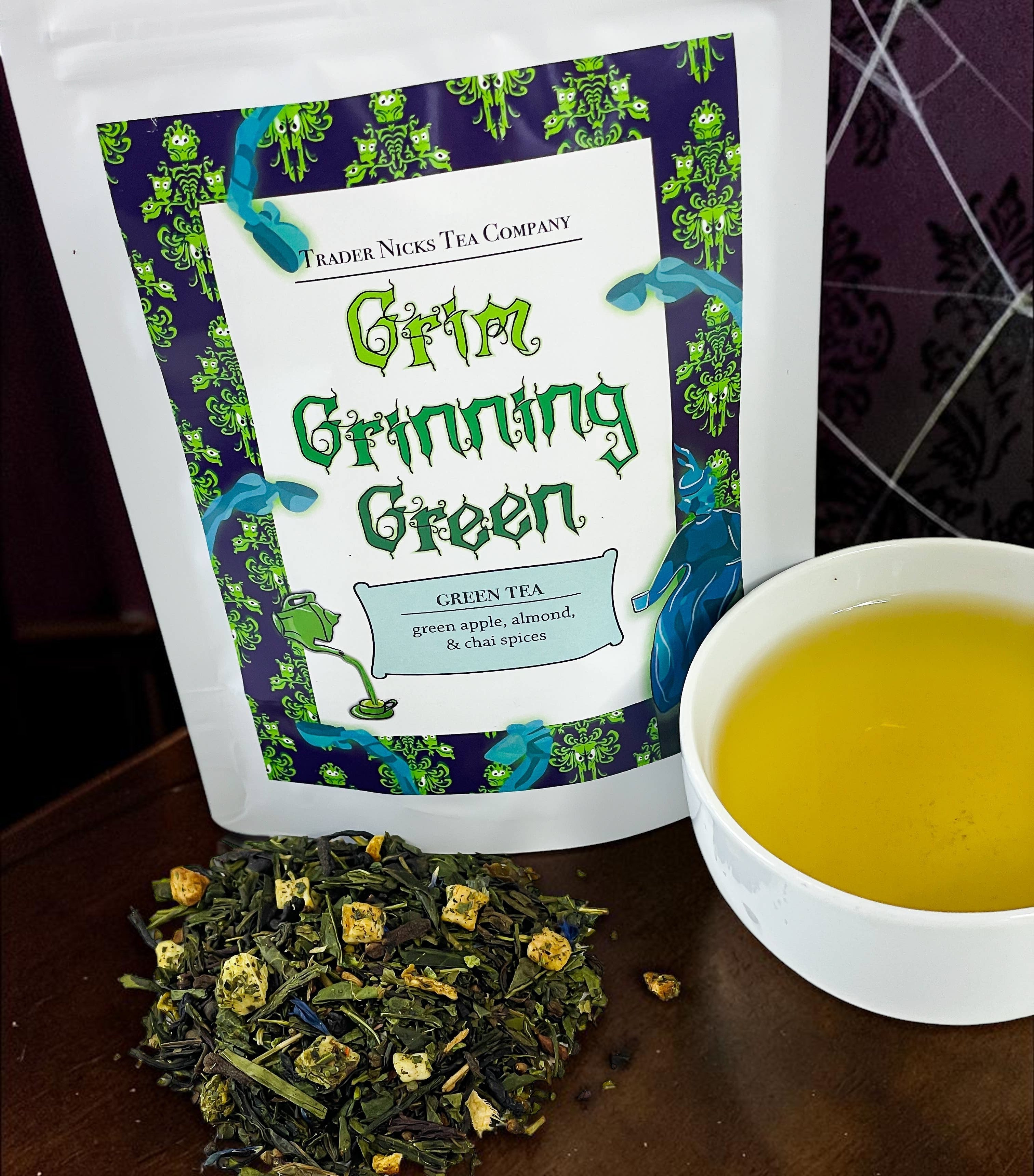 Halloween-Emporium Grim Grinning Green spiced apple green tea loose leaf blend with a cup of brewed tea